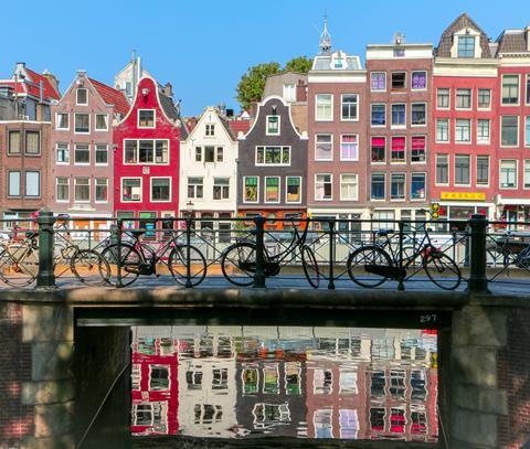 Beautiful Amsterdam with colourful buildings and bikes on a bridge.